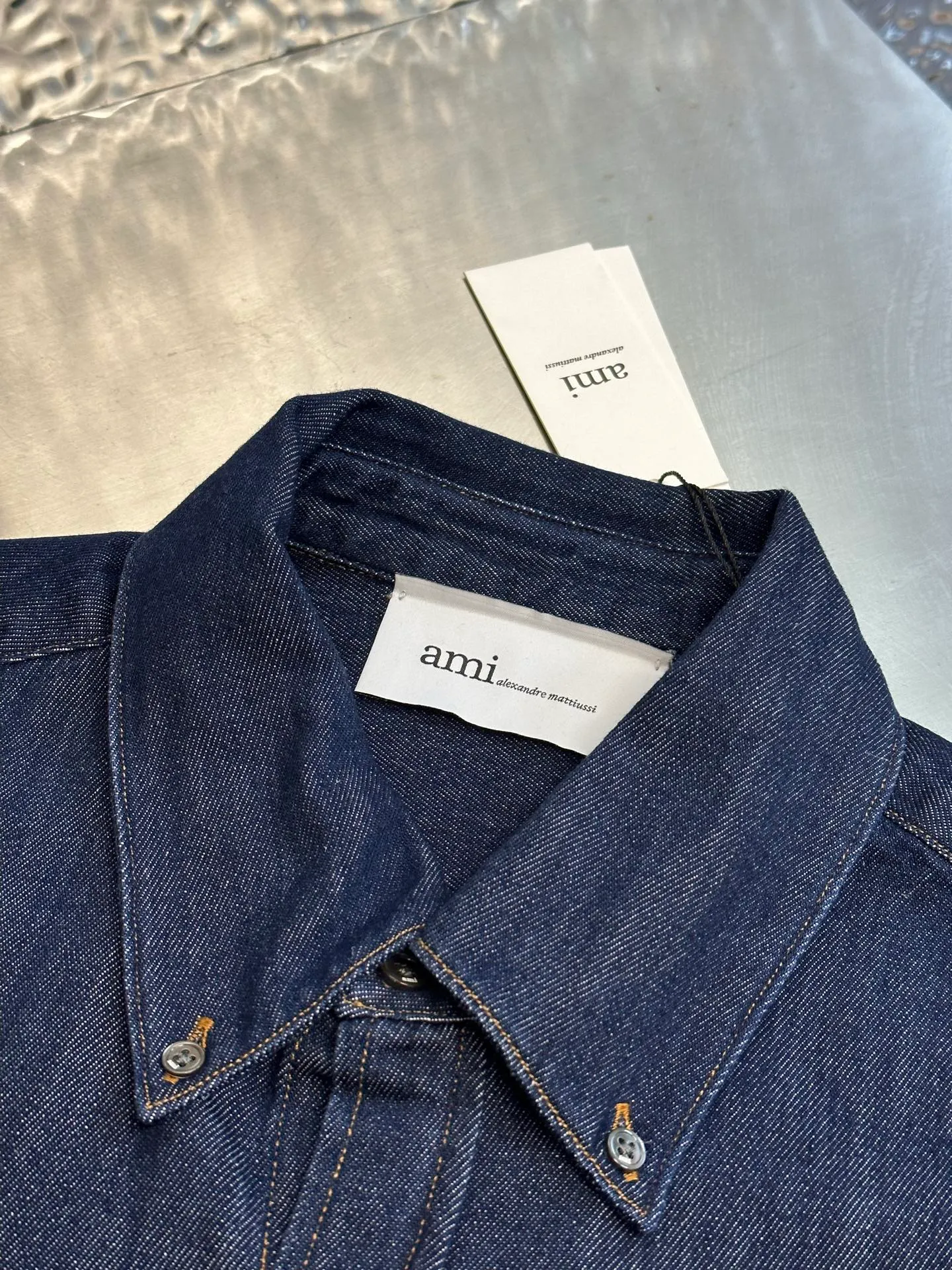 Ami Paris embroidered denim shirt is made of custom-made fermented denim material, with a deep twilight blue as the background color. It is pure and rich, with a golden brown heart on the chest. It is small but eye-catching, injecting agility and elegance into the tough denim. Using imported machine embroidery technology, advanced computer control systems and precision mechanical components, Ami love embroidery operations are realized. Using fried sand hand-rubbing technology, the surface of the denim material will be naturally faded and worn by processing on the sand-fried sand machine. Then, special tools are used to physically damage the surface of the denim material by hand, maintaining the original texture and details while increasing its uniqueness. Stir-fried snowballs, fried salt, specially prepare the corresponding solution, add a certain amount of dye, soak the denim material in it to absorb the solvent, and then scrub and dry it to further fade and oxidize it. size：s m l xl
